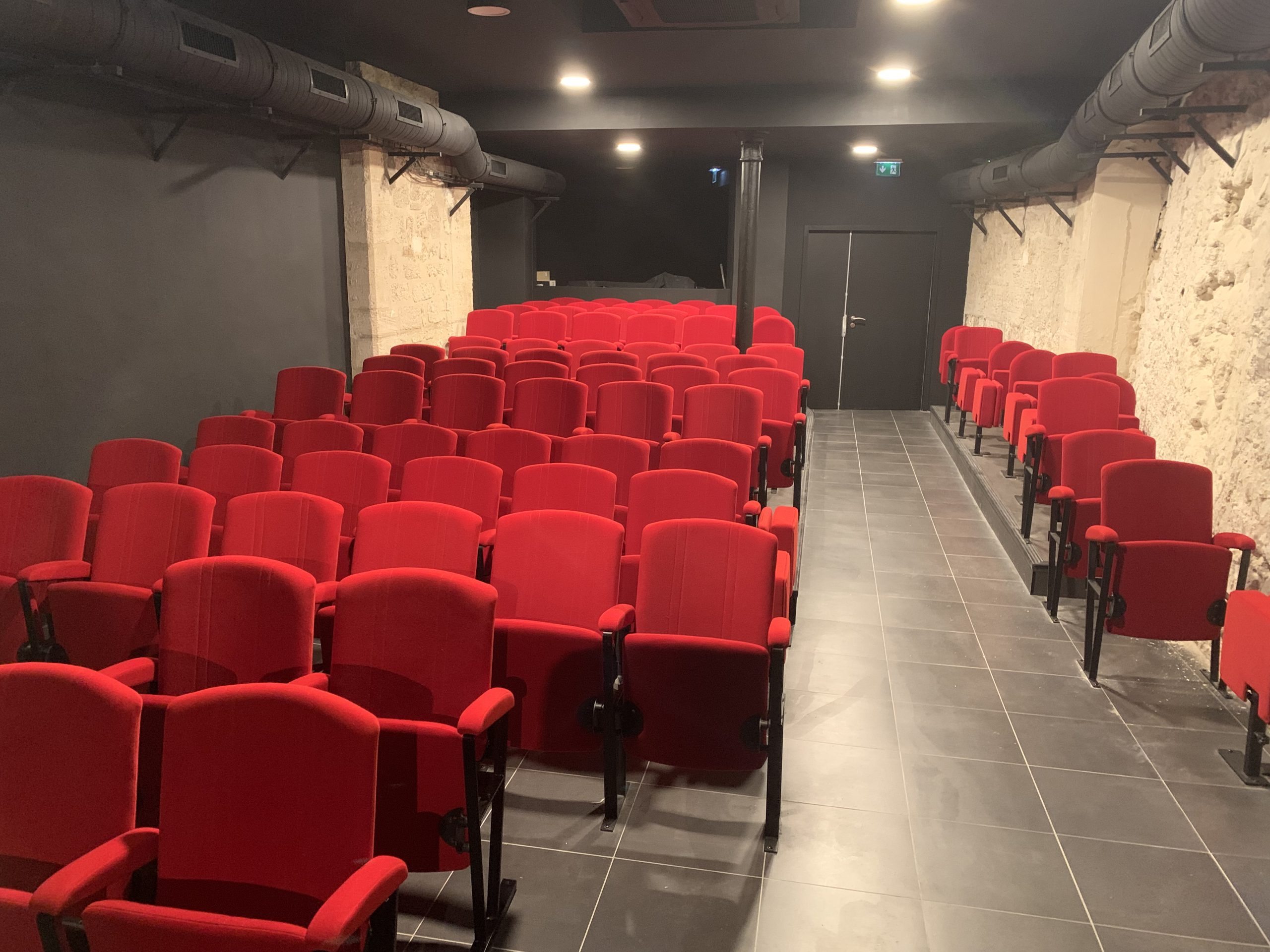 La salle de L'Oriflamme et ses 91 fauteuils rouges en velours, face à la scène